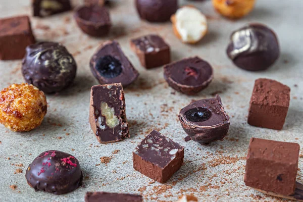Hafif taşlı arka planda çikolatalı trüf ve şekerler. Ev yapımı çikolatalı trüf ve kakao tozlu şekerler. Kapat..
