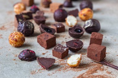 Hafif taşlı arka planda çikolatalı trüf ve şekerler. Ev yapımı çikolatalı trüf ve kakao tozlu şekerler. Seçici odak.