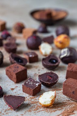 Hafif taşlı arka planda çikolatalı trüf ve şekerler. Ev yapımı çikolatalı trüf ve kakao tozlu şekerler. Seçici odak.