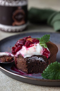 Mini çikolatalı kek ya da seramik tabakta kremalı, kirazlı ve naneli kek. Çikolatalı şeker. Seçici odak.