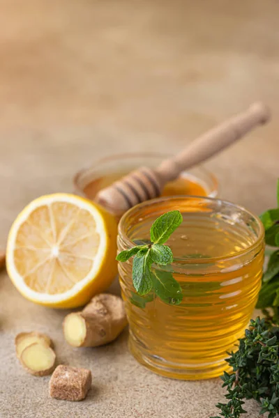 Tè alla menta calda e timo con radice di zenzero, limone e miele, fondo in cemento chiaro. Tisana. — Foto Stock