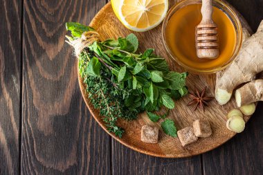 Nane, kekik, zencefil kökü, limon, bal ve kahverengi şeker. Zencefil ya da bitki çayı yapmak için gerekli malzemeler..