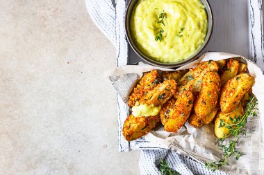 Seramik kasede kekik ve peynir soslu fırında patates, hafif taş zemin. Üst Manzara. Boşluğu kopyala.