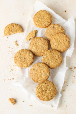 Sağlıklı yulaf ezmesi ya da tohum ve fındıklı çok tahıllı kurabiyeler, açık beton arka plan. Seçici odaklanma. Üst görünüm.