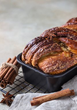 Tarçınlı babka ya da siyah metal ızgarada kremalı Brioche ekmeği. Tarçınlı ekmek. Avrupa Paskalya tatlı ekmeği. Kahvaltı için ev yapımı hamur işi. Seçici odak.