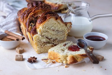 Tarçın ve esmer şekerli babka mı yoksa reçelli ve sütlü brioche ekmeği mi? Kahvaltı için ev yapımı hamur işi. Seçici odak.