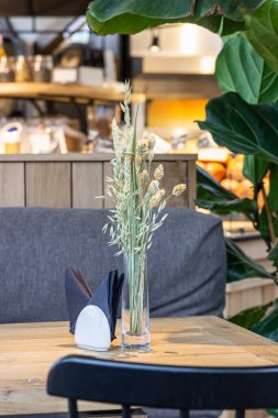 Tahta masadaki cam vazoda buğday kulakları. Kamış ya da kuru bitkiler. Çevre konsepti. Minimalist iç kafe, kahve evi..