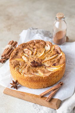 Tahtada tarçınlı elmalı turta, açık beton arka plan. Elma ve baharatlı Semolina keki. Ev yapımı mannik..