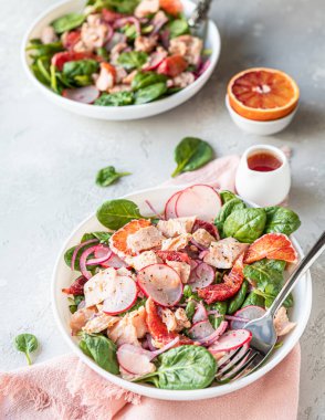 Somon, ıspanak, turp ve portakal sosuyla servis edilen kırmızı portakallı taze salata..