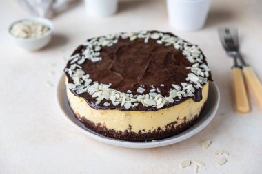 Çikolata jölesi ve bademle süslenmiş leziz kremalı cheesecake, açık beton arka plan. Kremalı tatlı yok..