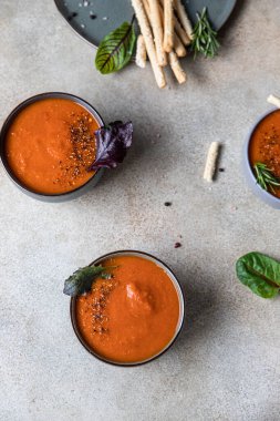 Üç kase domates çorbası ya da biber, biberiye ve ekmek çubuklarıyla birlikte gazpacho. Üst Manzara. Uzayı kopyala Seçici odak.