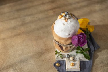 Geleneksel Ortodoks tatlı ekmeğiyle Paskalya kompozisyonu. Kulich krema, şeker şeklinde yumurta ve lale ile süslenmiş. Seçici odaklanma. Boşluğu kopyala.