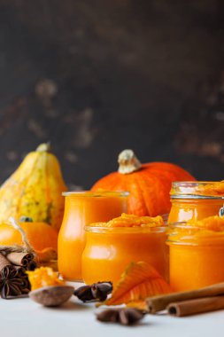 Farklı cam kavanozlarda farklı baharatlar ve taze balkabaklarıyla kabak püresi. Sonbahar ya da kış yemekleri. Hafif arkaplan.