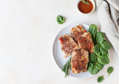 Portakal sosu, ıspanak ve biberiye ile servis edilen kızarmış hindi ya da tavuk göğsü, açık beton arka plan. Sağlıklı dengeli yiyecekler. Üst görünüm.