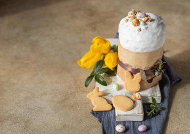 Geleneksel Ortodoks tatlı ekmeğiyle Paskalya kompozisyonu. Kulich krema, şeker şekilli yumurta, paskalya kurabiyesi ve lale ile süslenmiş..