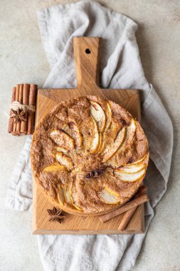 Tahtada tarçınlı elmalı turta, açık beton arka plan. Elma ve baharatlı Semolina keki. Ev yapımı mannik. Seçici odak.