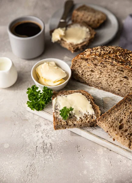 Pane multigrano artigianale appena sfornato con burro e patè. Colazione con caffè, pane a fette, burro e patè di fegato. Sfondo grigio chiaro. — Foto Stock