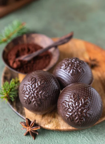 Ízletes kakaóbombák mályvacukorral és csokoládéval fából készült tányéron fenyőágakkal és fűszerekkel. Trendi téli forró ital. — Stock Fotó