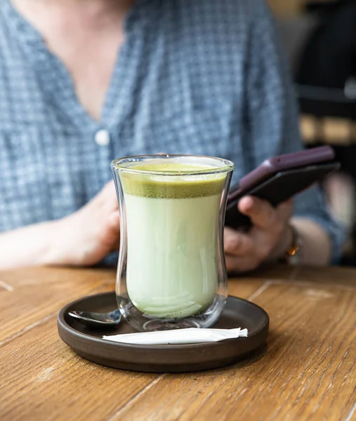 Grüner Tee Matcha Latte in Glasschale auf Holztisch im Café. Perfektes Getränk zum Frühstück. — Stockfoto