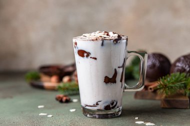 Marshmallow ve kakaolu sıcak çikolata ya da yeşil beton arka planda çikolata bombası. Köknar dalları ve baharatlarla kış kompozisyonu.