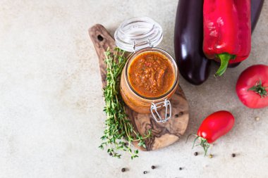 Kavanozda sebze havyarı, patlıcan, dolma biber, domates ve kekik. Ev yapımı reçeller. Vejetaryen mutfağı. Sonbahar hasadı. Üst görünüm.