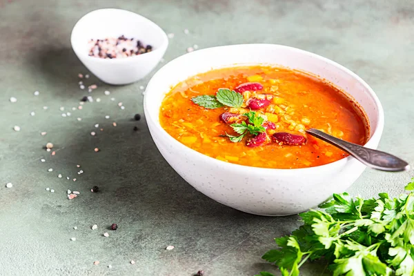 Bir kase ev yapımı kırmızı fasulye ve mercimek çorbası, ekmek ve maydanoz. Sebze baharatlı çorba. Seçici odak.
