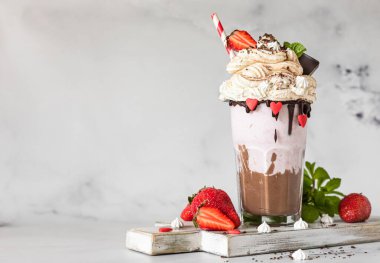 Çikolata ve çilekli milkshake ile birlikte dondurma ve krema, mini krema, çikolata, çilek ve naneli bardakta servis edilir. Seçici odaklanma. Boşluğu kopyala.