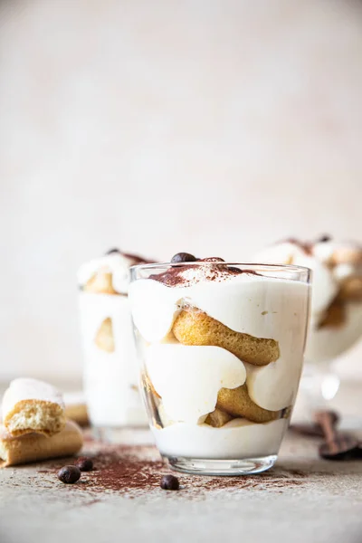 Tradizionale dolce italiano tiramisù in vetro. Dessert di porzione aromatizzato al caffè a base di ladyfingers e mascarpone decorato con cacao in polvere. — Foto Stock