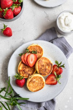 Süzme peynirli krep ya da çilekli börek ve yoğurt. Sağlıklı kahvaltı ya da öğle yemeği. Syrniki..