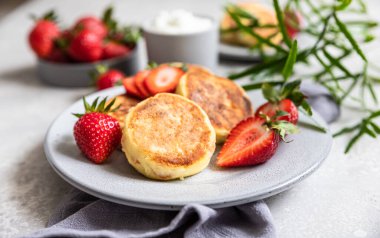 Süzme peynirli krep ya da çilekli börek ve yoğurt. Sağlıklı kahvaltı ya da öğle yemeği. Syrniki..