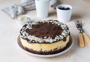 Çikolata jölesi ve bademle süslenmiş leziz kremalı cheesecake, açık beton arka plan. Kremalı tatlı yapmak yok. Seçici odak.