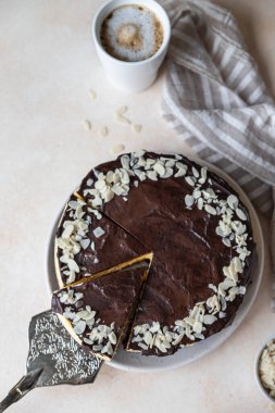 Çikolata jölesi ve bademle süslenmiş leziz kremalı cheesecake, açık beton arka plan. Kremalı tatlı yapmak yok. Seçici odaklanma. Üst görünüm.