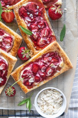 Çilekli, krem peynirli ve pasta kağıdında bademli börek. Üst görünüm.