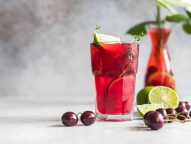 Kokteyl ya da kiraz ve limonlu limonata, gri taş arka plan. Mocktail. Soğuk yaz içeceği.
