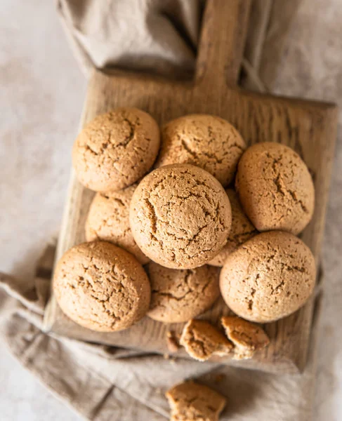 Haferflockenkekse auf hölzernem Schneidebrett, brauner Betongrund. Gesunder Snack oder Dessert. — Stockfoto