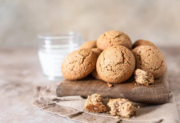燕麦饼干在木制切菜板上与一杯牛奶，棕色混凝土背景。健康小吃或甜点. — 图库照片