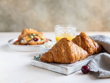 Krem peynirli kruvasan sandviç, nektarin ve kiraz ve lezzetli kahvaltı hazırlamak için taze malzeme. Seçici odak.