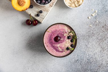 Yabanmersinli meyve suyu kasesi, taze böğürtlenli badem dilimleri ve tahta kesme tahtasında meyve. Üst Manzara. Seçici odak.