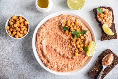 Nane ve limonla kavrulmuş kırmızı biberli humus garnitürü. Kırmızı dolma biber, limon ve naneli nohut püresi. Vejetaryen atıştırması. Seçici odaklanma. Üst görünüm.