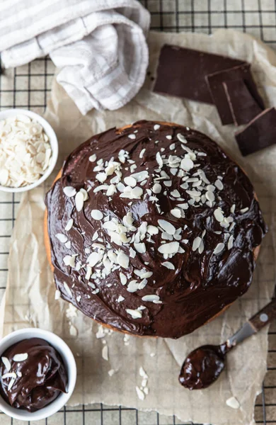 Домашний шоколад и ванильный торт украшены шоколадной глазурью и орехами на черной металлической решетке. Мраморный торт. — стоковое фото