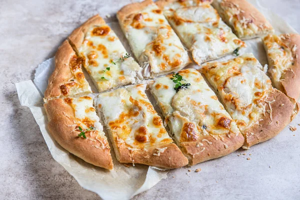 Rzymska pizza z białym mięsem z kurczaka lub indyka i sera, betonowe tło. Pinsa. Tradycyjna rzymska pizza z kurczakiem. — Zdjęcie stockowe