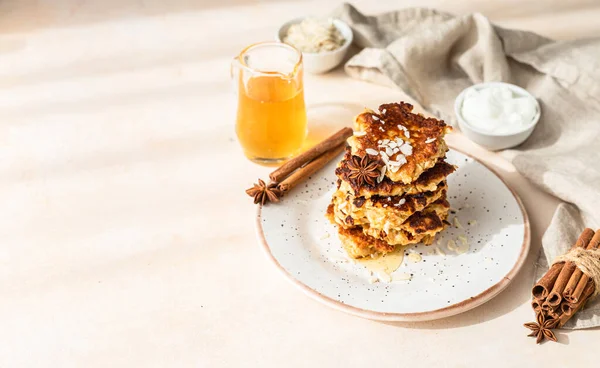 Stack of delicious apple pancakes or fritters with honey, spices and almond. Sunny morning. Autumn breakfast. Selective focus. Copy space.