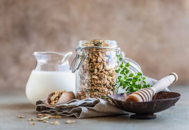 Ev yapımı granola ya da balkabağı tohumlu müsli, bal ve süt çimentoda. Sağlıklı beslenme. Lezzetli ve kolay bir kahvaltı ya da atıştırmalık. Seçici odak.