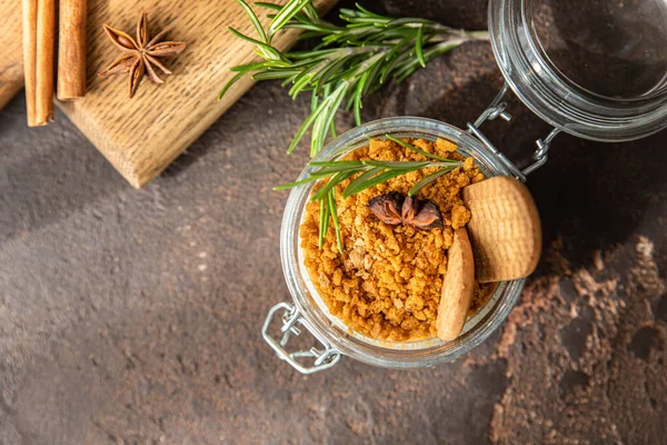 Cam kavanozda, biberiye, anason ve koyu kahverengi arka planla süslenmiş kremalı cam bir tatlı. Peynirli kek, çerez ya da puding yok. Üst görünüm.