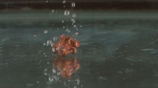 Metallmalm som faller i vatten — Stockvideo