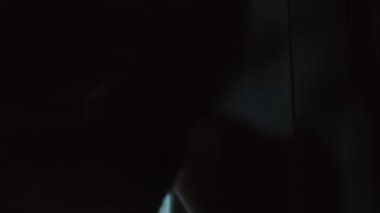 Adam yağmurlu pencereden dışarı bakıyor.