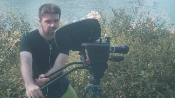 Mężczyzna za pomocą kamery filmowej na zewnątrz — Wideo stockowe