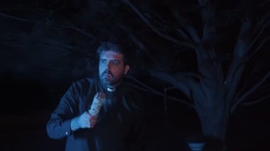 Rahip evi yakmak için adaçayı kullanıyor.