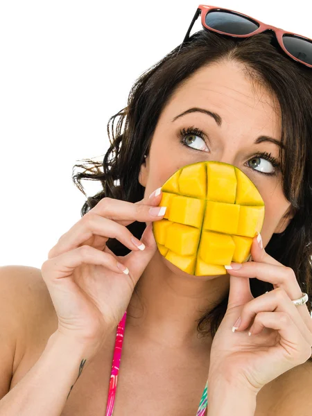 Friska ung kvinna som innehar en bit av mango frukt — Stockfoto