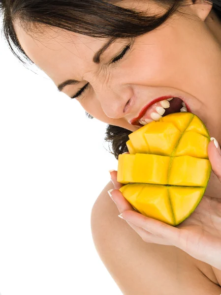 Gezonde jonge vrouw die een stukje mango fruit vasthoudt — Stockfoto